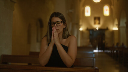 Obraz premium A young hispanic woman prays solemnly in an italian church, reflecting a beautiful moment of christian faith and devotion.