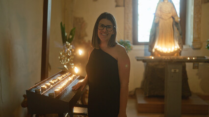 A beautiful young hispanic woman stands in a church in italy, illuminated by candlelight and a statue of a saint, creating a serene and spiritual christian setting.