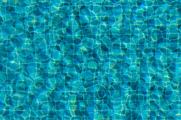 Mesmerizing Turquoise Ripples Dance Under the Sun in a Serene Swimming Pool During a Bright Summer Afternoon