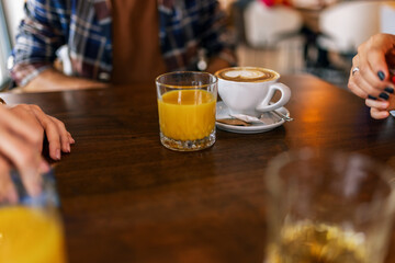 Friends hanging out at the cafe. They drink and talk.
