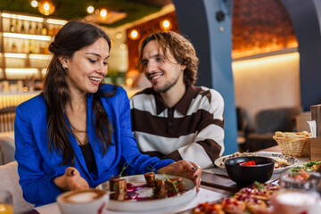 Couple eating in a restaurant. Food looks delicious and tasty. Food and drink concept.