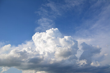 a large cumulus cloud that is in the sky with the blue sky on the background
