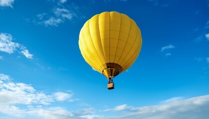 Naklejka premium yellow hot air balloon gracefully rises in the blue sky offering a unique view of the world below evoking freedom and joy on a sunny day