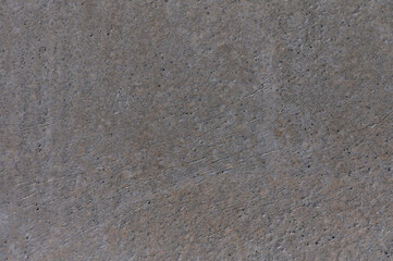 Textured surface of weathered concrete revealing intricate patterns and subtle shades in natural light