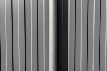 Obraz premium Grey fence made of metal sheet. Metal fence post