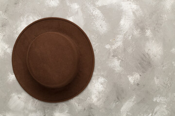 Brown autumn hat on concrete background, top view