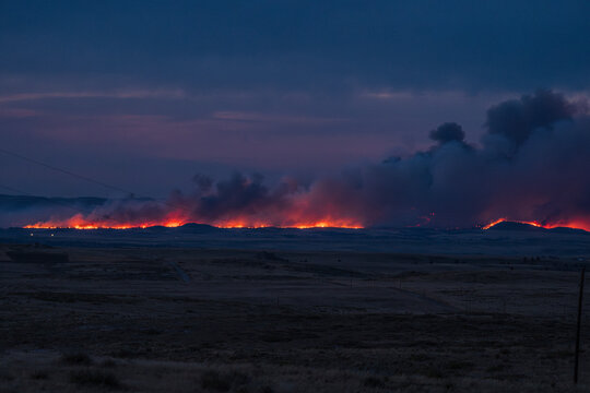 Wyoming wildfire landscape glowing fire at dusk night time guernsey forest fire