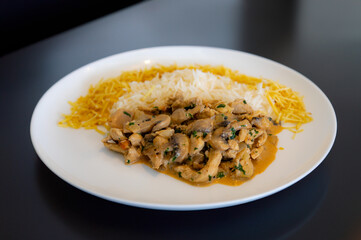 Traditional chicken stroganoff with mushrooms, straw potatoes and white rice