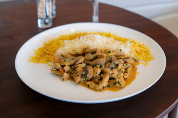 Traditional chicken stroganoff with mushrooms, straw potatoes and white rice