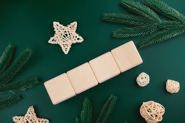 Blank wooden blocks on emerald background, top view, Christmas banner, winter background 