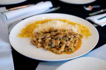 Traditional chicken stroganoff with mushrooms, straw potatoes and white rice