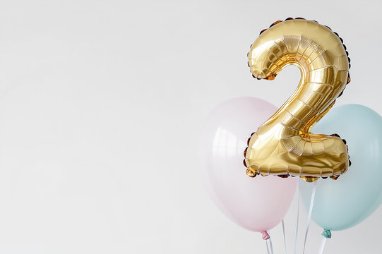 Gold number 2 balloon surrounded by pastel-colored balloons for second birthday celebration, party decoration, or special event with a simple and elegant aesthetic
