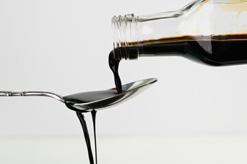 Pouring soy sauce in a spoon.