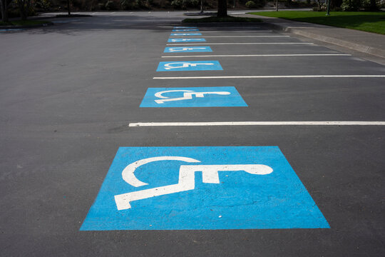 Handicapped parking signs on the ground in a parking lot.