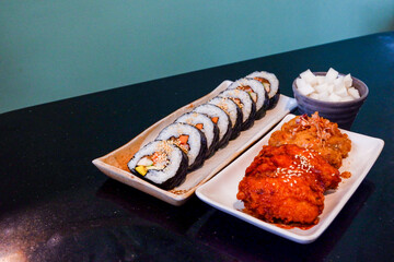 Korean foods served on a dining table,Gimbap,Fried chicken, radish,kimchi on table in korean restaurant,street food,copy space..