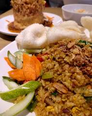 Close up view of typical Indonesian fried rice topped with carrot slices and cucumber slices. Deep of field selective focus. Can be used for food menu photos.