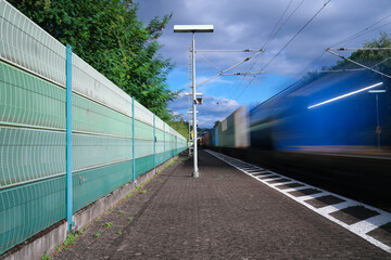 Lärmschutzwand an Bahnstrecke zur Reduzierung von Bahnlärm und vorbeifahrender Güterzug -...