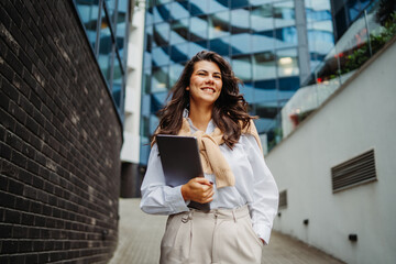 Fototapeta premium Young businesswoman going to work in front of modern business building