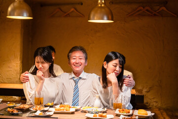 宴会の席で女性と肩を組むビジネスマン