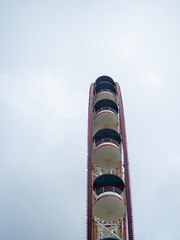 Ferris wheel from bottom to top. Attraction cabins against the gray sky. At the resort.