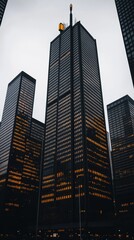 Fototapeta premium 高層ビル群に囲まれた夜景の都市風景、秋の薄曇り空の下で灯りが輝く