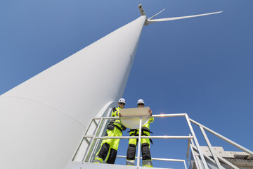 Engineers are having a discussion at wind turbine field