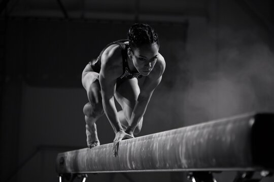 Gymnast on the Balance Beam: A powerful image of a female gymnast preparing to perform on the balance beam, showcasing strength, focus, and determination.