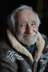 Portrait of an elderly man with a warm smile wearing a cozy, patterned sweater, capturing wisdom, warmth, and a joyful moment in life.