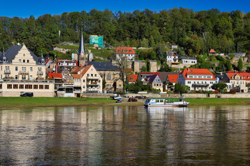 Obraz premium Panoramablick auf Stadt Wehlen an der Elbe mit Personenfähre und historischer Altstadt, sommerliche Flusslandschaft im Nationalpark Sächsische Schweiz, Sachsen, Deutschland