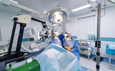 Surgeons in a high-tech operating room. A team of surgeons carefully conducts a procedure in a well-equipped operating room, showcasing their skills and teamwork.