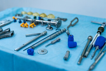 Surgical tools on a blue drape. A variety of surgical instruments are carefully laid out on a blue table cover, ready for use in a medical procedure.