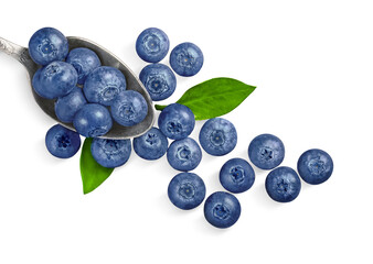ripe blueberries in a spoon and next to it isolated on white background