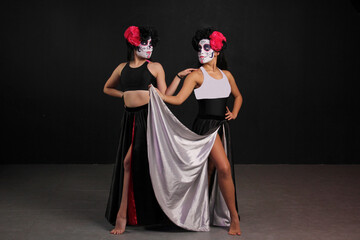 Young Mexican women with catrina makeup dance and celebrate the Day of the Dead in Mexico