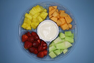 a dish with pieces of fresh fruit in disposable dishes