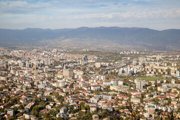 Fototapeta premium Skopje, a thriving urban panorama The city of Skopje, seen from above Aerial view of the Macedonian capital Skopje, a mosaic of colors and shapes where the mountains meet the metropolis.