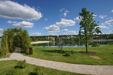 Summer landscape with a beautiful landscape of the river bank. Blue sky with small clouds.