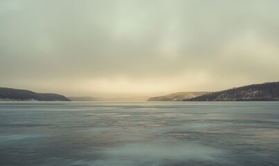 Obraz premium A large body of water with a cloudy sky in the background