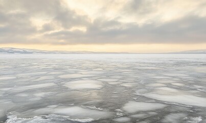 Obraz premium A large, empty, snow-covered field with a cloudy sky