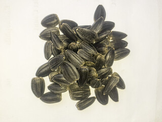 Top view ripe and dry peel sunflower black seeds  pile isolated on white background 