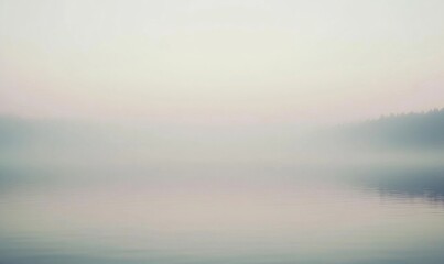 Fototapeta premium A foggy lake with trees in the background