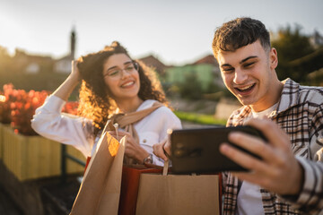 Boyfriend take a self portrait with his girlfriend hold shopping bags