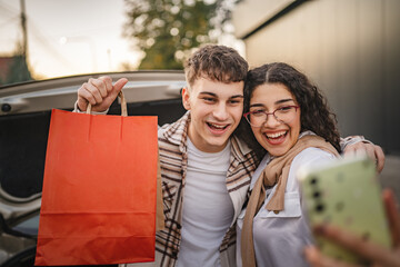 Girlfriend take a self portrait with her boyfriend hold shopping bags