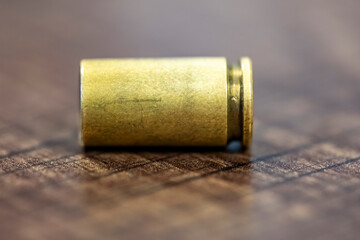 A bullet is sitting on a wooden table