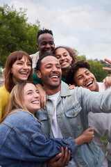 Vertical. Cheerful group of friends taking smiling selfie. Group of young people having fun together outdoors at park in the city enjoying travel in vacation holidays.