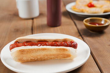 Hot Dog Topped with Ketchup on a White Plate In Diner