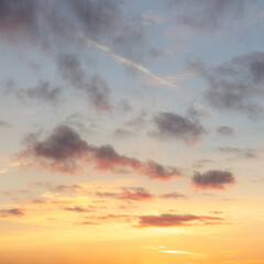 Vibrant sunset sky with a few scattered clouds, blending warm oranges, pinks, and purples for a peaceful, picturesque scene.