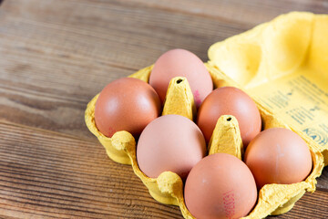 Closeup macro of pasture raised farm fresh dozen brown eggs store bought from farmer in carton box...