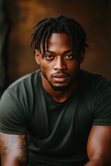 Fototapeta premium Portrait of a young African man with dreadlocks and tattoos in casual attire