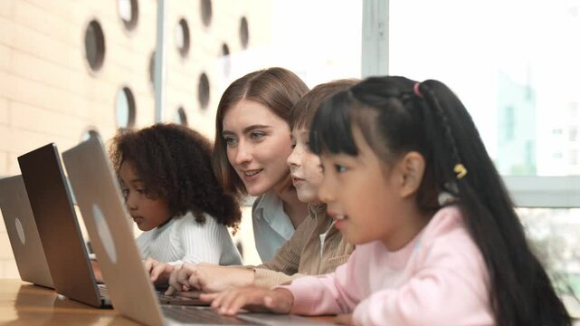 Smart teacher teaching and looking student using laptop at classroom. Professional instructor explained about programing engineering code or prompt while studying and learning program. Erudition.