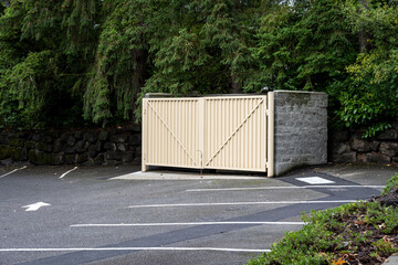 Commercial property parking lot with garbage dumpster enclosure, built from cement blocks and heavy...